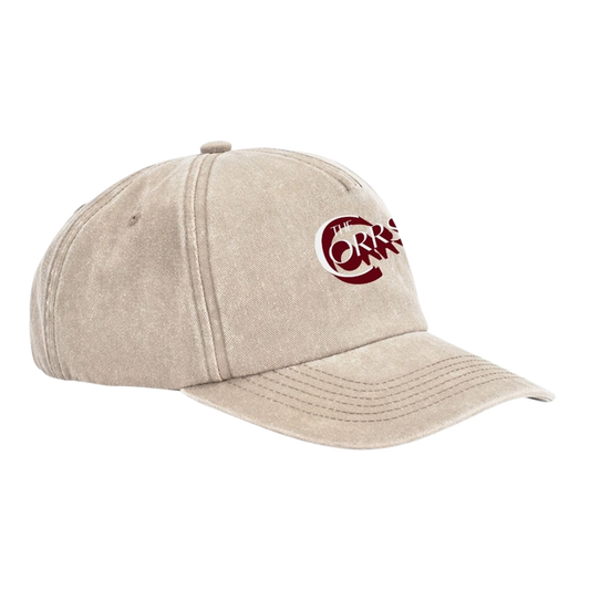 The Corrs Vintage Cap from The Corrs Store by National Merchandise is a light beige baseball cap with a red The Corrs logo on the front, displayed at an angle facing left on a plain background.