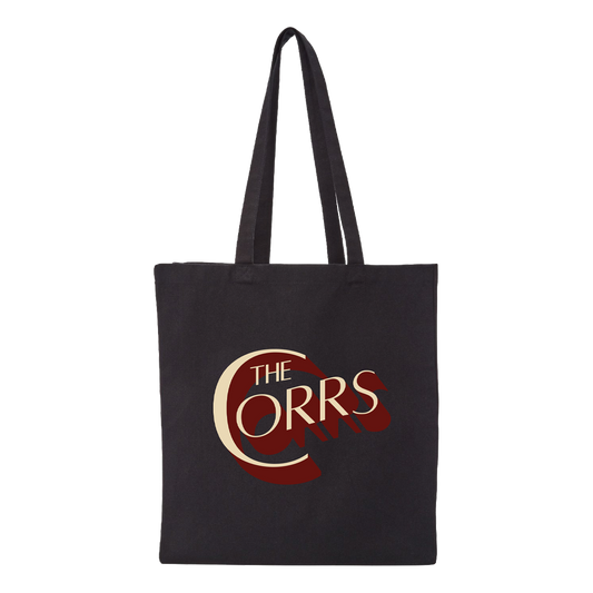 The Corrs Black Tote Bag from The Corrs Store by National Merchandise features a large stylized cream and dark red “C” with shadow detailing, along with The Corrs logo, printed and centered on the front.
